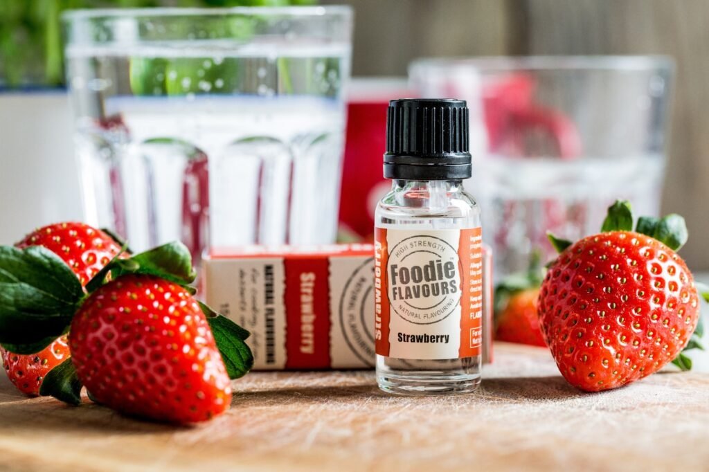 Butelki z aromatami spożywczymi i świeże truskawki